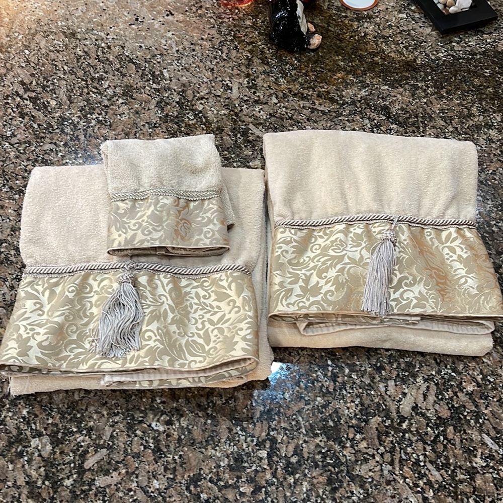 Set of two bath size towels and one washcloth that have tassels and rope trim